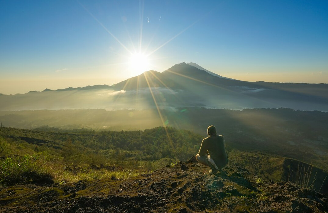person meditating at sunrise