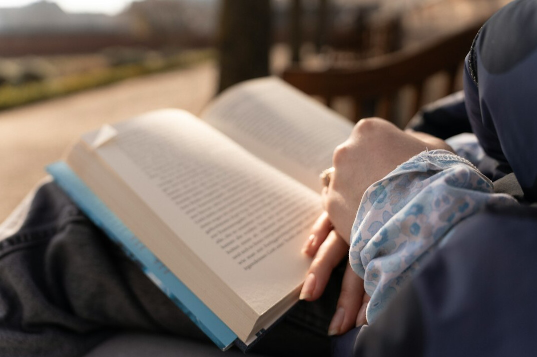 person reading book outdoors